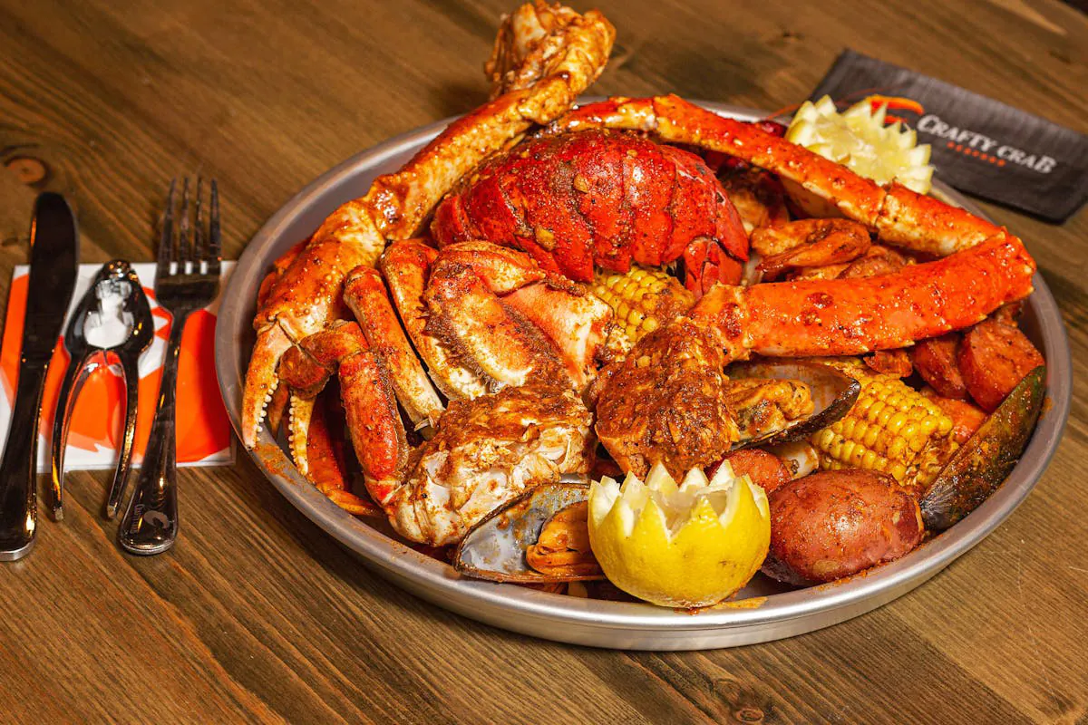 Large platter of crab legs, lobster, corn, and potatoes at Crafty Crab, a Seafood Restaurant in Wilmington