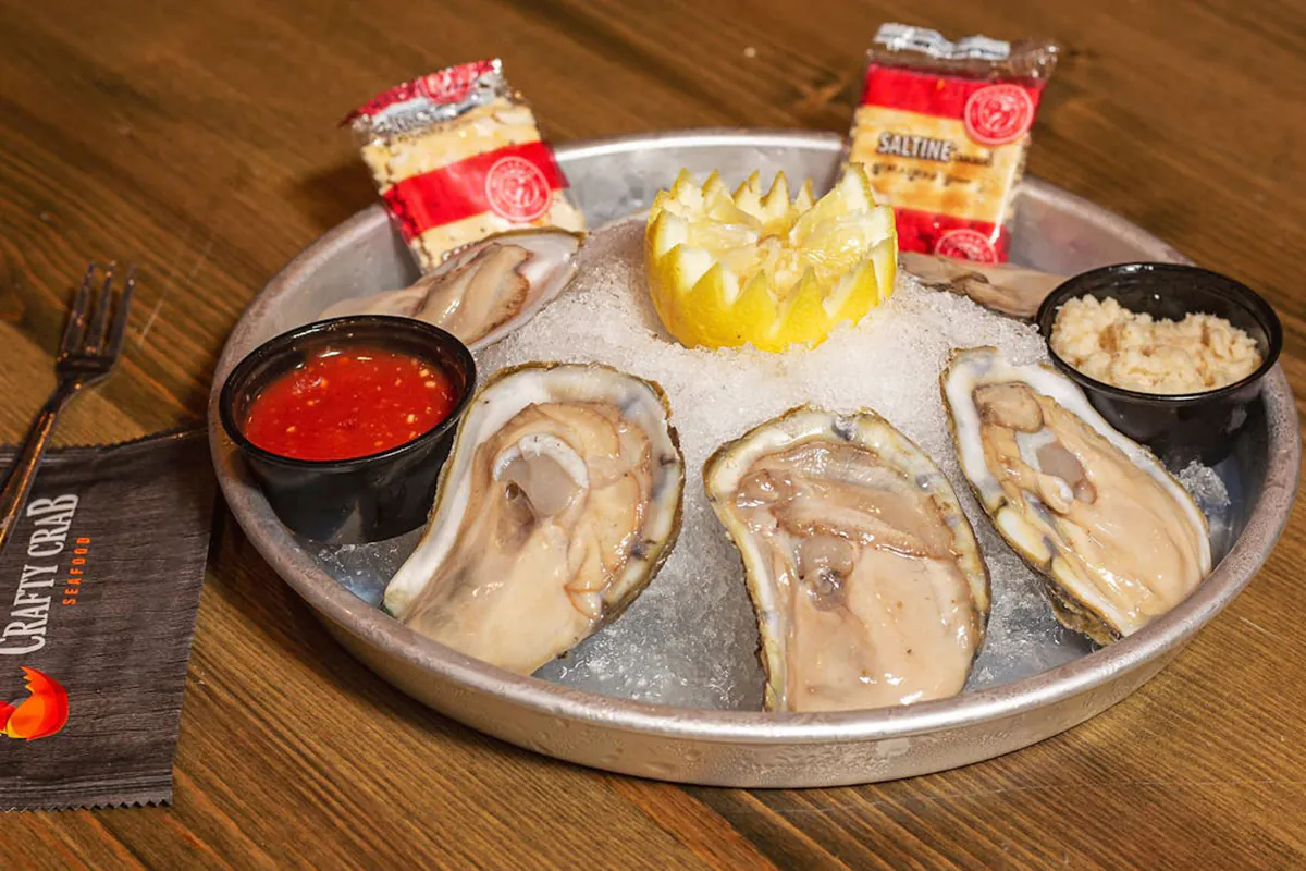 Fresh oysters on ice with lemon, crackers, and cocktail sauce at Crafty Crab, a Seafood Restaurant in Wilmington